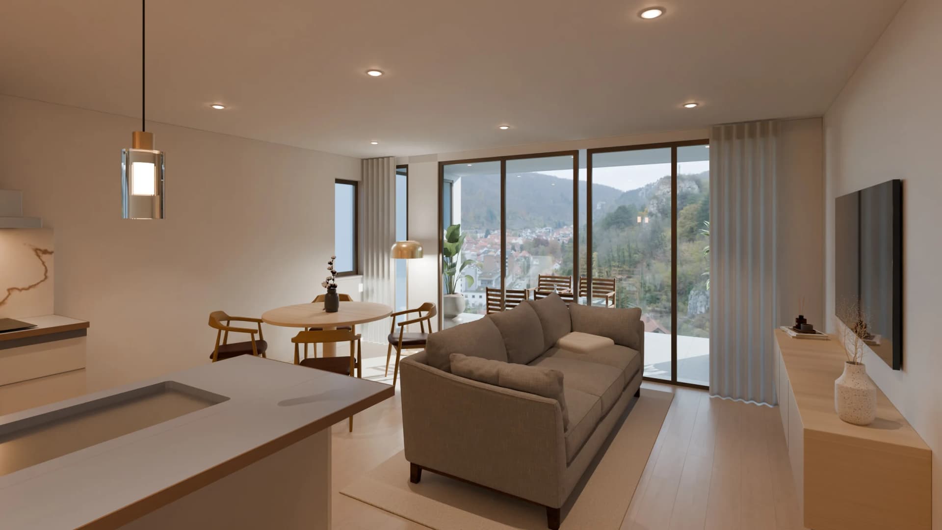 The flat's living room at midday: the kitchen island, the table, the sofa and, past the glazing, the valley and the town